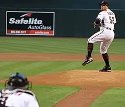Zach Godley beginning to throw a pitch, with a catcher blurry in the foreground