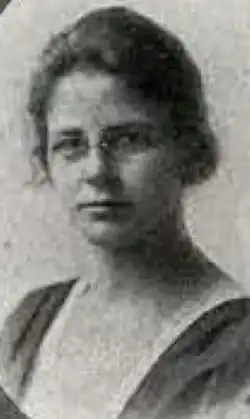 A young white woman with dark hair and glasses