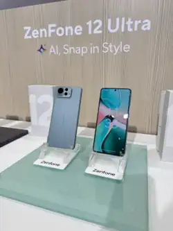 Two Zenfone 12 Ultra devices displayed on phone stands on a desk with a wooden textured background.