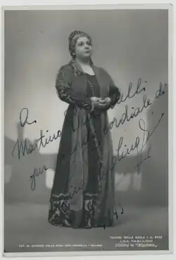A black and white photograph of a standing woman in costume, at full lenght