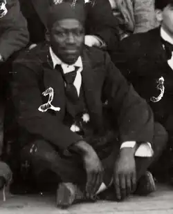 Griffon sits cross-legged among a group of people