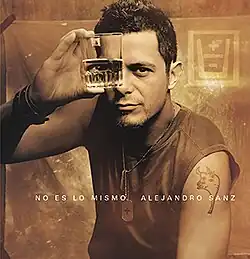 A sepia-toned photograph of Sanz with one eye looking through a half-filled glass.