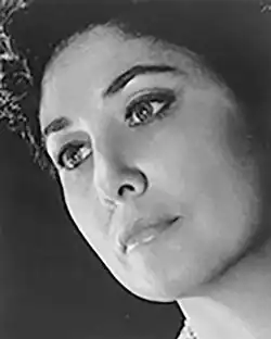 Black and white, three-quarter profile publicity glamour headshot of a woman of Italianate appearance in heavy stage makeup