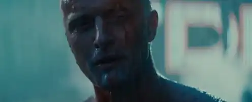 Headshot of Roy Batty, rain can be seen falling around him