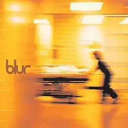 A nurse pushes a hospital bed. A patient, who is in the bed in this scene, is being rushed into the emergency ward of a hospital. The band's name/album title is seen on the center left.