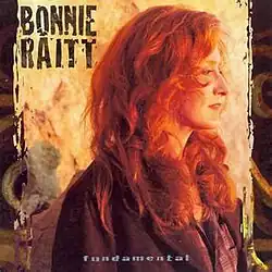 photo of Bonnie Raitt facing right in brown jacket with western motif