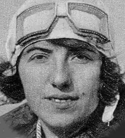 Black and white publicity shot of a half-smiling young woman with dark, bobbed hair, wearing a flying cap, with goggles on her forehead.