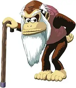 A thin, elderly gorilla scowling and standing with a cane. He has a long white beard, small glasses, and a taupe sweater-vest.