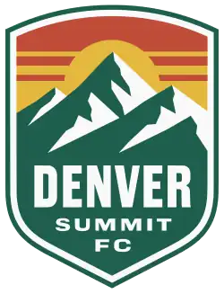 A shield depicting a green and white mountain range against a yellow sun and dark orange sky.