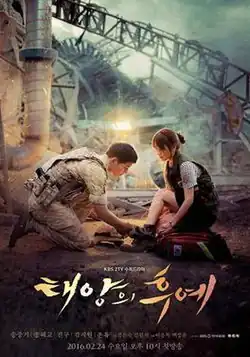 A soldier in desert camouflage kneels to tie the boot of a woman in a medical vest amidst the smoky ruins of a disaster site. Dramatic golden light illuminates the pair against a backdrop of twisted metal and the Korean title for "Descendants of the Sun"