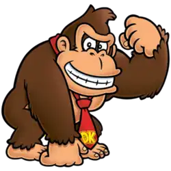 A brown gorilla with a tan brow and muzzle flexes his muscle while grinning. He wears a red tie with yellow initials reading "DK".