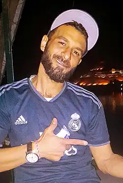 Egyptian man wearing a sports shirt and a hat as part of a globalized streetwear, 2019.