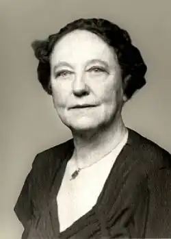 A middle-aged woman with short hair in a low-cut blouse