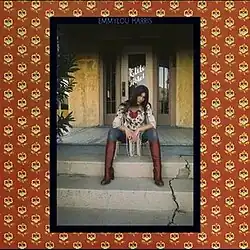 framed photo of Emmylou Harris in western clothes seated on steps in front of hotel door