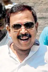 Das wearing a white kurta and sunglasses, mouth open, with his gang members behind.
