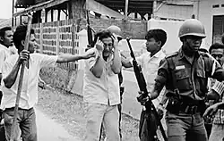 A Chinese Indonesian student being attacked by a crowd and led away by soldiers, 15 October 1965
