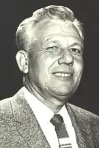 Black-and-white portrait of J. William Davis wearing a suit and tie, smiling slightly.