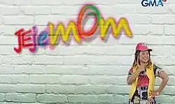 An image of Eugene Domingo, over a white wall. The series title is displayed on the upper left side of the image. The logo of GMA Network is displayed on the upper right side of the image.