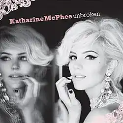 A black-and-white photo of Katharine McPhee next to a mirror. Both the artist's name and album title appear above her, colored in pink and white respectively.
