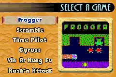 A horizontal screenshot of an orange selection screen. The title at the top reads "Select A Game". The left column lists six game titles: Frogger (which is highlighted), Scramble, Time Pilot, Gyruss, Yie Ar Kung-Fu, and Rush'n Attack. The right column displays a small screenshot of the game Frogger.