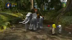 Indiana Jones sitting on top of an elephant, with Short Round and Willie Scott standing aside in the jungles of Pankot Region