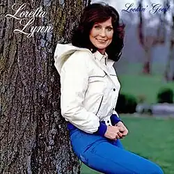 photo of Loretta Lynn in white jacket by tree