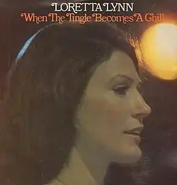 headshot photo of Loretta Lynn with stage light background