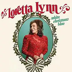 oval framed photo of Loretta Lynn in red with holly border