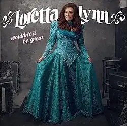 photo of Loretta Lynn in teal dress in dark room
