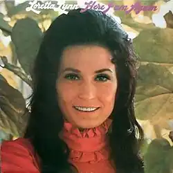 headshot photo of Loretta Lynn in front of plant leaves