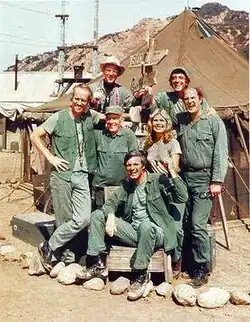 The cast from season 8 onward (clockwise from left): Mike Farrell, William Christopher, Jamie Farr, David Ogden Stiers, Loretta Swit, Alan Alda and Harry Morgan