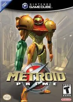 Samus Aran, the main character in Metroid Prime, is in a in a big, futuristic-looking powered suit with a helmet. There is a firearm on the right arm and large, bulky, and rounded shoulders, stands on an industrial-like corridor. Atop the image is the GameCube logo, and the text "Only for" in the upper left corner. In the bottom of the image, the title "Metroid Prime" in front of an insignia with a stylized "S", the Official Nintendo Seal of Quality, Nintendo's logo, and ESRB's rating of "T".