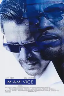 With focus on their heads, Colin Farrell as James "Sonny" Crockett and Jamie Foxx as Ricardo "Rico" Tubbs, both equipped with sunglasses, stand right next to each other.