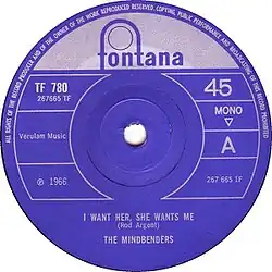 The British single label for the Mindbenders version of the Rod Argent song "I Want Her, She Wants Me". The label is blue and round.
