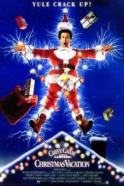 A man in a santa suit wrapped in Christmas lights is electrocuted; his spread-out limbs create an outline resembling a Christmas tree topper/star.