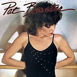 half-length photo of Pat Benatar in black top holding ballet barre behind her back, in thought