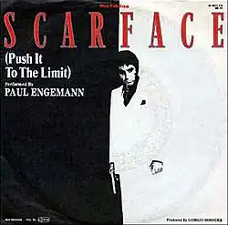 Single cover. It pictures a man who stands holding a gun with his right hand. He wears a suit. The background is bicolor. The text "(Push It To The Limit)" and "Performed by Paul Engemann" is written to his right. Above this line, the word "Scarface" is written in big capital letters.