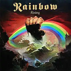 Cover art of the album Rising, showing a giant fist rising from the raging sea and clenching a rainbow