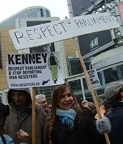 Toronto protest in Yonge-Dundas Square showing a related sign about Canada and Iraq War resisters