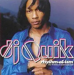 The cover features DJ Quik wearing a silk blue Versace shirt and gold chain, with his perm hair slightly blowing in the wind to his right. The artist's name appears below him, colored in white with some pink behind it. Under the word 'Quik' is the album title, with the subtitle 'Over 70 minutes of commercial-free music' also under it, both colored in white.