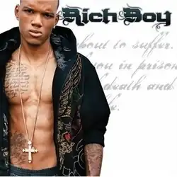 The cover features Rich Boy wearing an open black hoodie showing his chest, with a cross necklace over his stomach. The artist's name appears on the right side, colored in black. Behind him is cursive text from the tattoo on his right pectoral muscle.