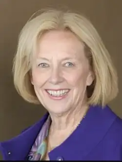 Portrait of a blonde Caucasian woman wearing a purple jacket