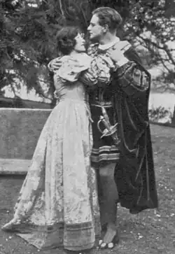 Young white couple in Renaissance costumes in fond embrace