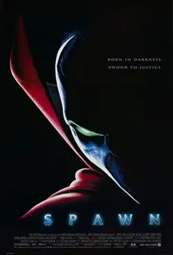 Partially seen against a dark black background is a green-eyed and masked face, wearing a red collar and cape