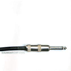 A guitar cable jack plug against a white backdrop