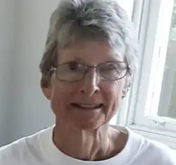 Suzanne Rees wearing glasses and a white shirt