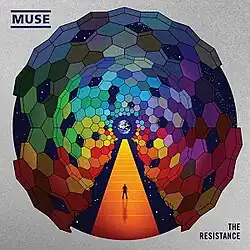A man walking on orange steps, surrounded by many coloured hexagons. The earth is in the background. Outside of the image are the artist's name (top left) and the album title (bottom right).
