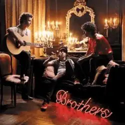 The band members sitting on couches, casually, facing each other