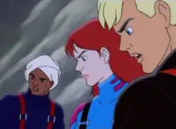 Characters Hadji Singh, Jessie Bannon, and Jonny Quest are shown with faces emphasized in an ice setting. Hadji is very tan-skinned, wearing a turban, a navy blue sweater, and red suspenders. Jessie is pale-skinned with red hair and green eyes and is wearing a blue snowsuit with pink highlights and black suspenders. Jonny has blonde hair and blue eyes and is lightly tanned; he is wearing a black snowsuit with red suspenders.