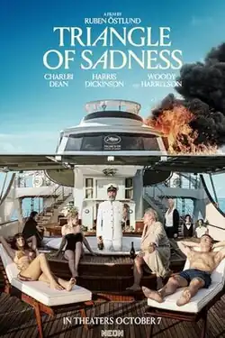A group of people are seen lounging in a yacht (seen on fire) with the captain sitting on a Jacuzzi holding a glass of champagne and a large bottle. Staff members are seen on the background.